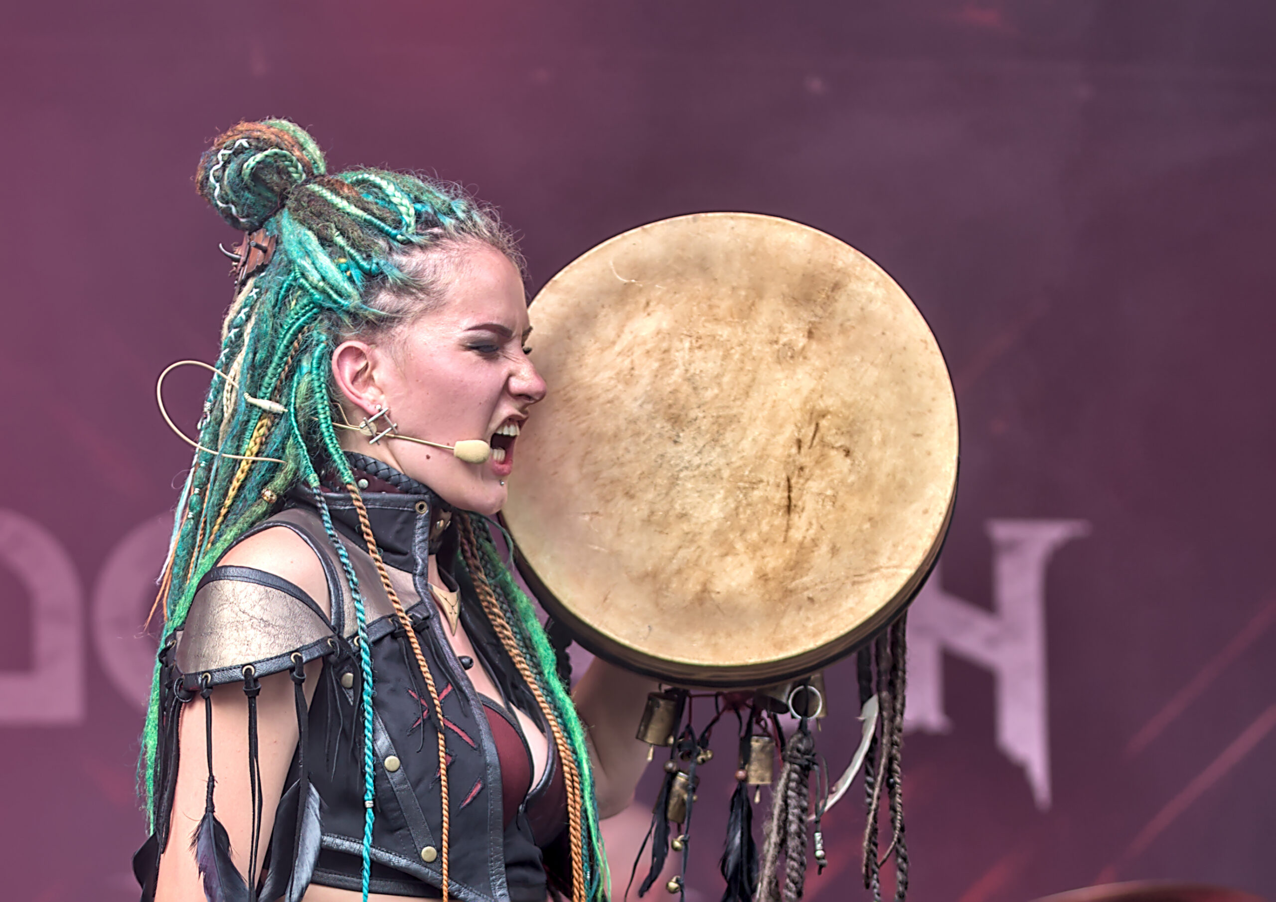 Creatief artiestenportret van een zangeres met groen gevlochten haar en een traditionele trommel tijdens een live festival optreden - Matt West Visuals